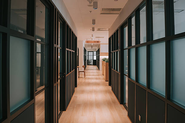 intérieur moderne du couloir de bureau avec cloisons en verre et parquet